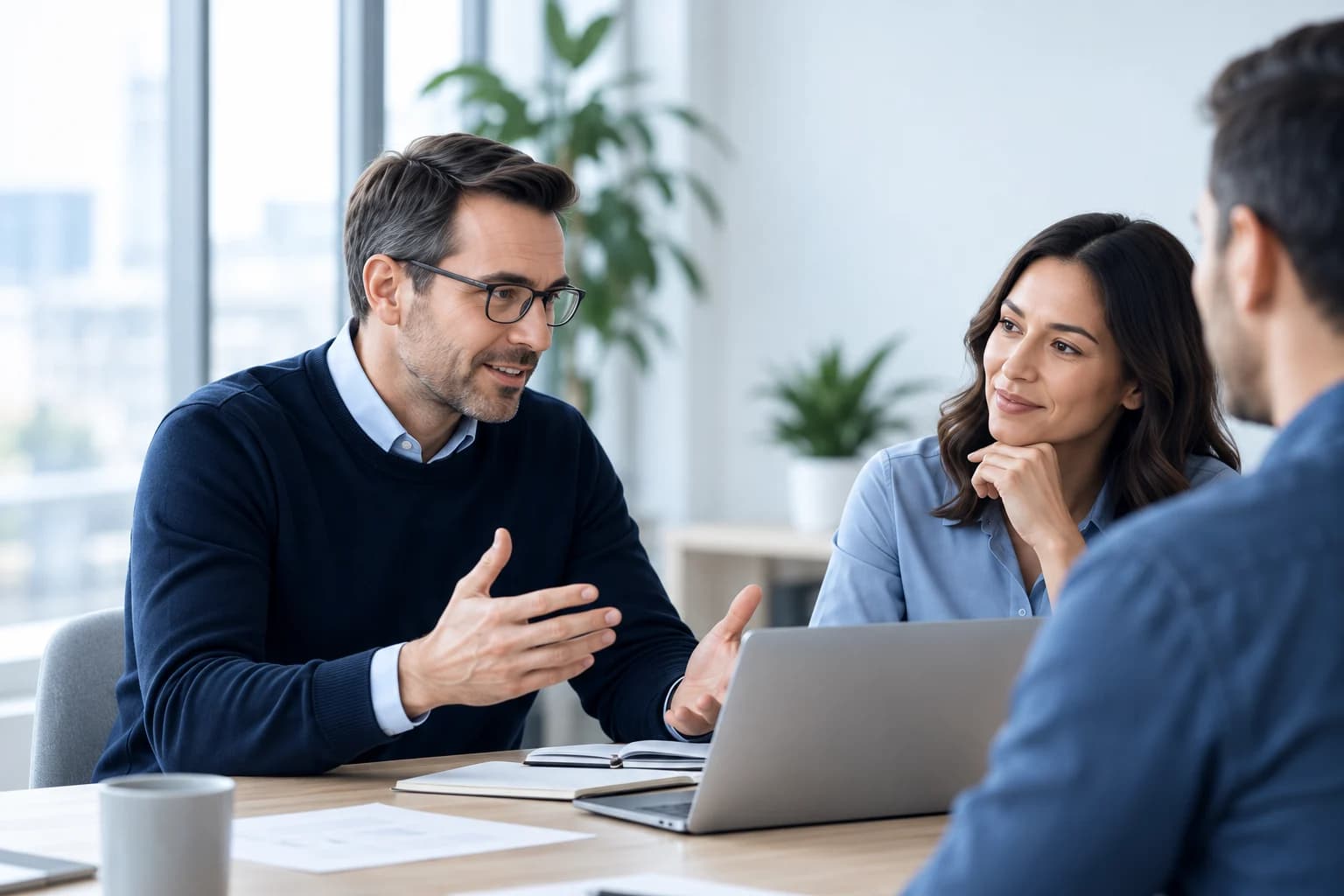 A team reviewing work together around a laptop